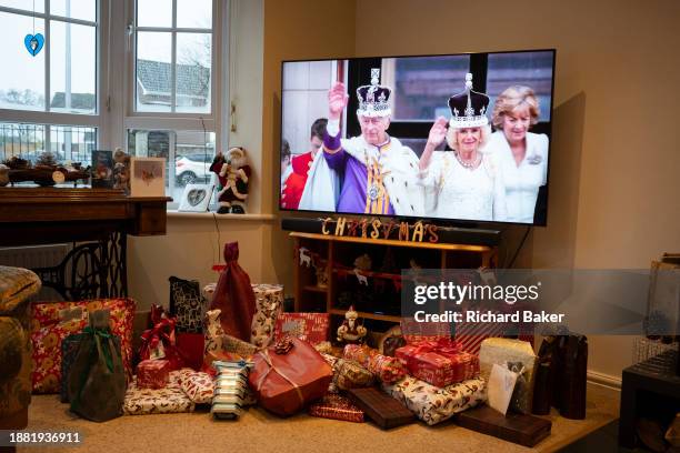 Above unopened Christmas presents, King Charles and Queen Camilla are seen at the king's coronation, during his first Christmas broadcast as monarch...