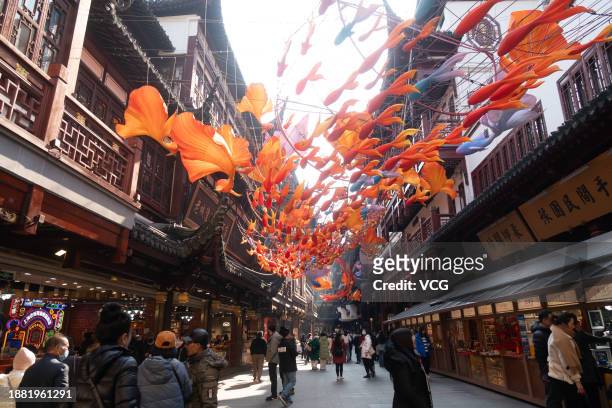 Tourists walk under fish-shaped lanterns at Yuyuan Garden ahead of its annual lantern show to greet upcoming Chinese New Year, the Year of the...