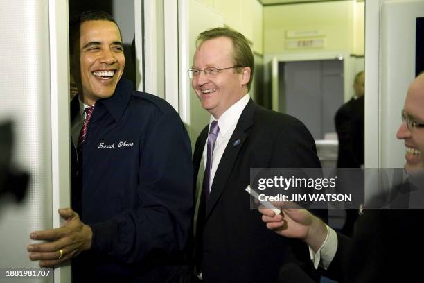 President Barack Obama comes back to the press cabin to show off his new coat with White House Press Secretary Robert Gibbs shortly after boarding...