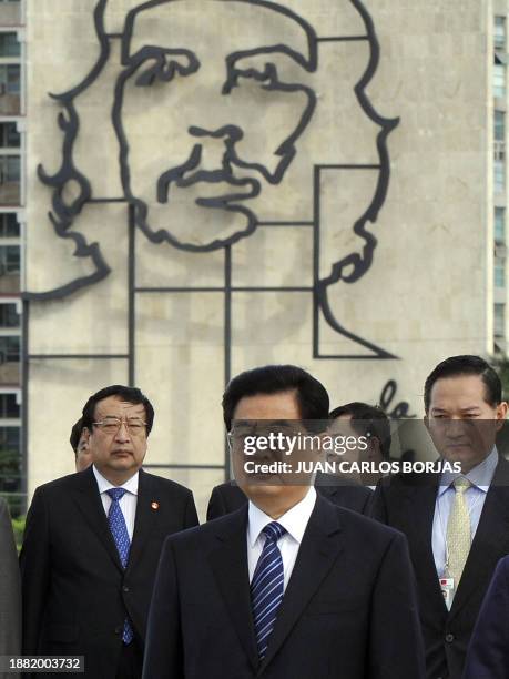 Chinese President Hu Jintao walks in Havana's Revolution Square as members of the Chinese delegation look on during a ceremony at the Jose Marti...
