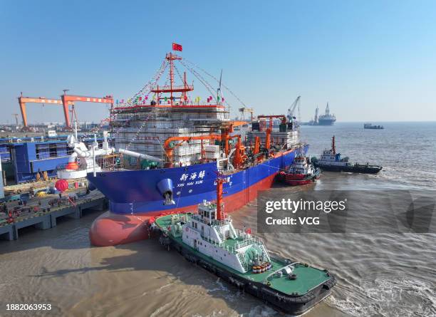 Tugboats push the world's biggest and China's first dual-fuel powered trailing suction dredger, named Xinhaixun, 155.7 meters in length and 32 meters...