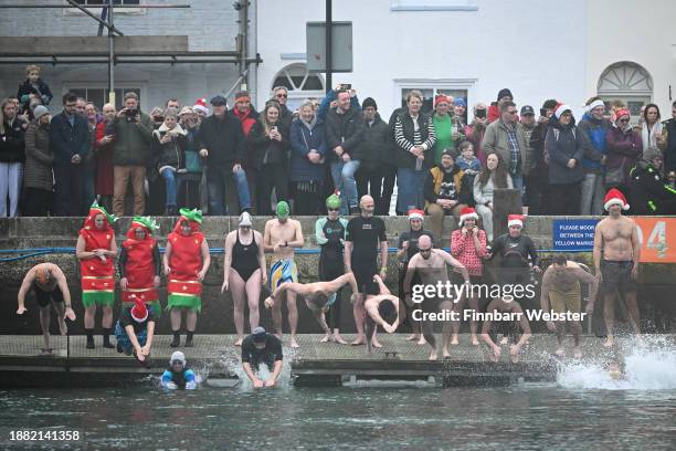 Swimmers take part in the traditional harbour swim, on December 25, 2023 in Weymouth, England. Around 450 swimmers, many of whom dress up in seasonal...