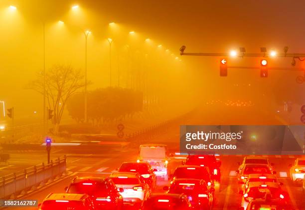 Vehicles drive on the city's main road shrouded in thick smog and polluted air at night in Huai 'an city, Jiangsu province, China, December 28, 2023.