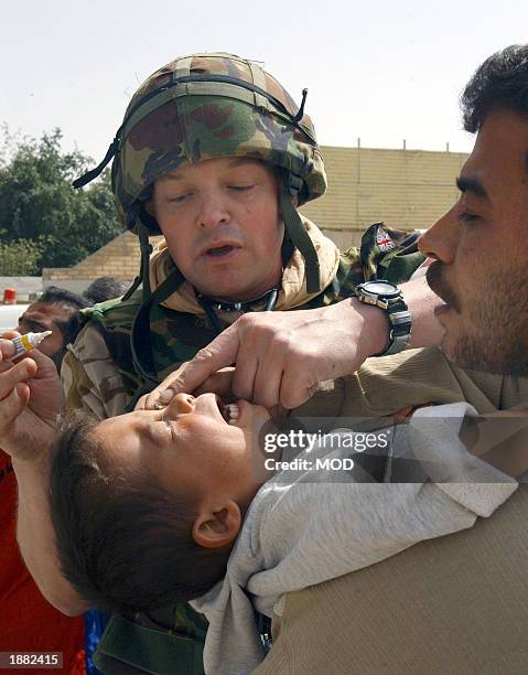 In this handout photo from the British Ministry of Defence, Colonel Dunken Robertson of 4 General Support Regiment Medics provides medical attention...