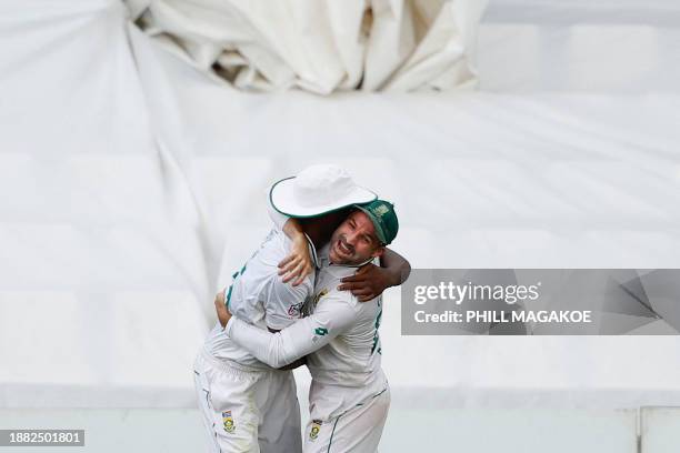 South Africa's Kagiso Rabada celebrates with South Africa's Dean Elgar after the dismissal of India's Virat Kohli during the third day of the first...