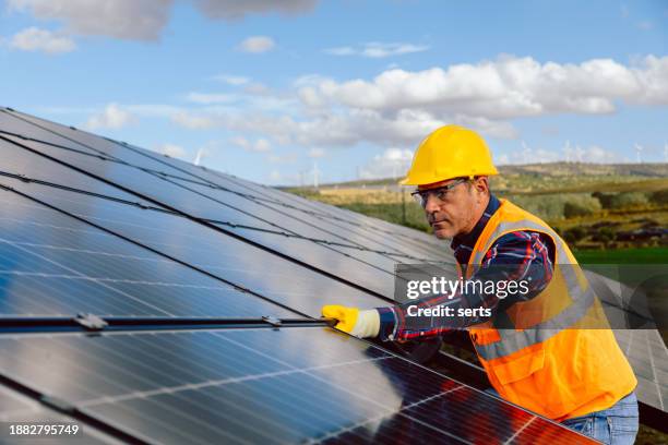 révolution de l’énergie renouvelable : un travailleur installe le remplacement d’un panneau solaire - panneau photovoltaique photos et images de collection