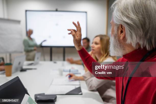 senior man raising hand at business meeting - reds training session stock pictures, royalty-free photos & images
