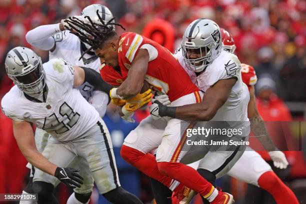 Isiah Pacheco of the Kansas City Chiefs loses his helmet as he's tackled by Divine Deablo of the Las Vegas Raiders during the third quarter at GEHA...