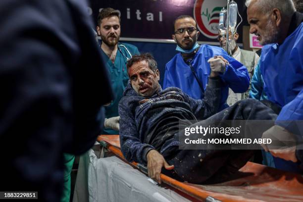 Graphic content / Medics take in charge a wounded man at Kuwait hospital in Rafah in the southern Gaza Strip following an Israeli strike on December...