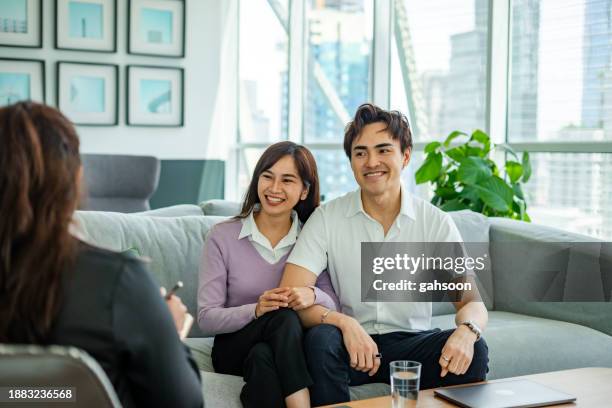 happy couple satisfied on counselling appointment - community engagement stockfoto's en -beelden