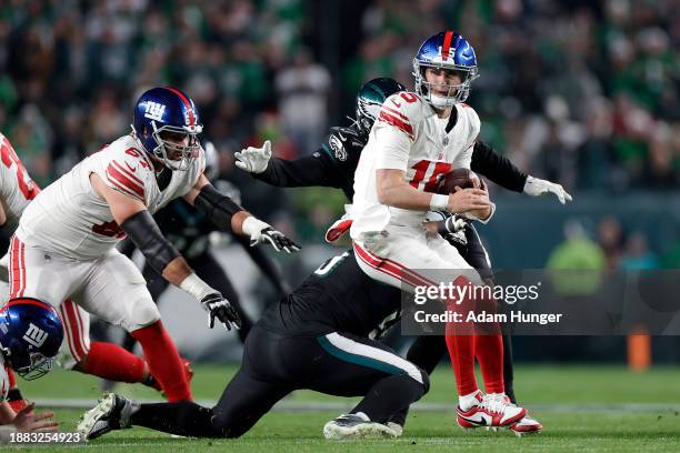 Tommy DeVito of the New York Giants avoids a tackle by Josh Sweat of the Philadelphia Eagles during the second quarter at Lincoln Financial Field on...