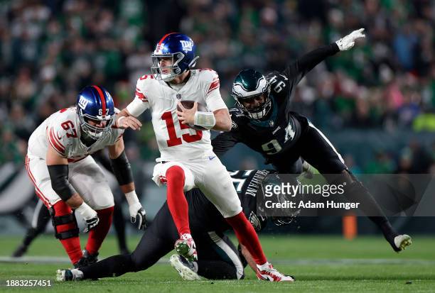 Tommy DeVito of the New York Giants avoids a tackle by Josh Sweat of the Philadelphia Eagles during the second quarter at Lincoln Financial Field on...