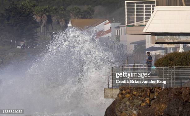 Ventura, CA A man stands on a balcony in Faria Beach as huge waves crash on the shore Thursday, Dec. 28, 2023 in Ventura, CA.