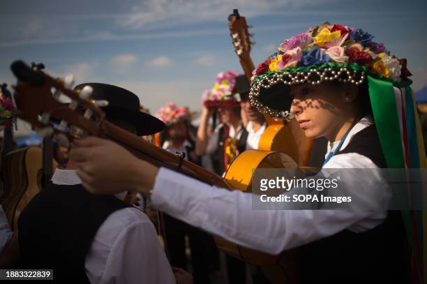 Woman dressed in a traditional costume plays a guitar as she takes part in the festival. The 61th edition of the Verdiales Flamenco Dance contest, an...