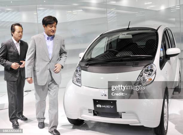 Japan's auto giant Mitsubishi Motors president Osamu Masuko and Japan's battery giant GS Yuasa president Makoto Yoda introduce the MMC's first mass...