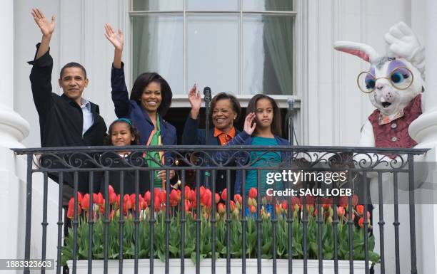 President Barack Obama waves from the Truman Balcony alongside First Lady Michelle Obama, their daughters Sasha and Malia, Marian Robinson ,...