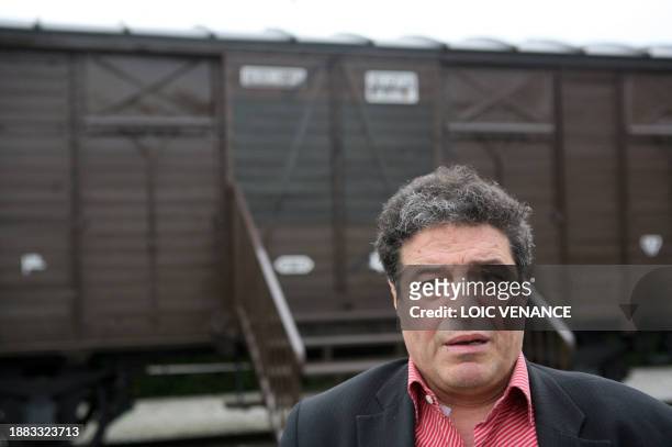 Mouloud Aounit, president of the MRAP stands on April 11 outside Paris, in front of the wagon of the memorial of the Drancy camp, repainted after it...