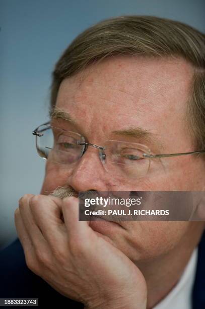 World Bank Group President Robert Zoellick listens as he sits at a table during an announcement that Liberia has reduced its foreign debt by buying...