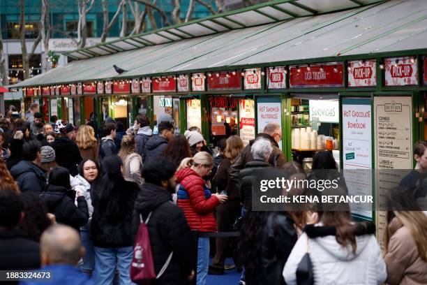 People buy food as they visit the Winter village in Bryant Park, New York City, on December 28, 2023
