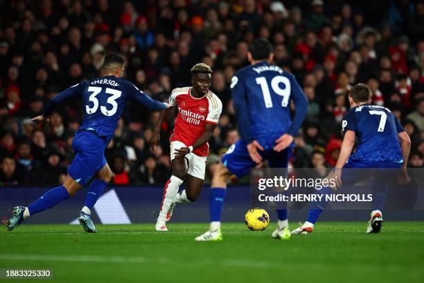 Arsenal's English midfielder Bukayo Saka fights for the ball with West Ham United's Italian defender Emerson, West Ham United's Mexican midfielder...