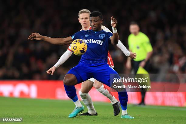 Mohammed Kudos of West Ham United in action with Oleksandr Zinchenko of Arsenal during the Premier League match between Arsenal FC and West Ham...