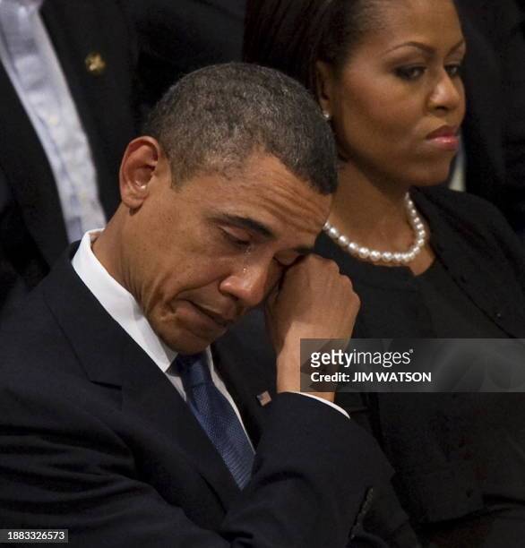 President Barack Obama wipes away a tear as he sits next to First Lady Michelle Obama at the funeral service for Dr Dorothy Height at Washington...