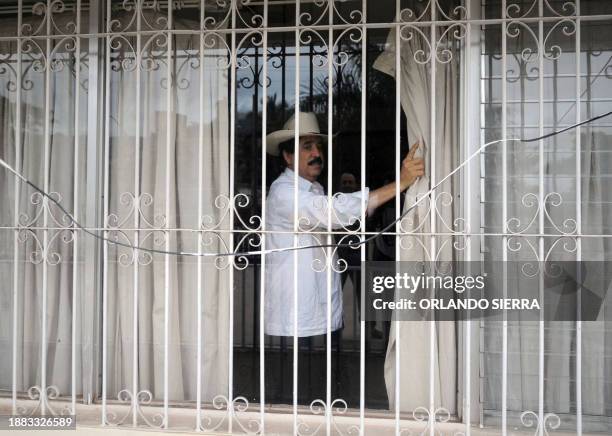 Toppled Honduran President Manuel Zelaya watches the city from a window of the Brazilian embassy in Tegucigalpa September 30, 2009. Security forces...
