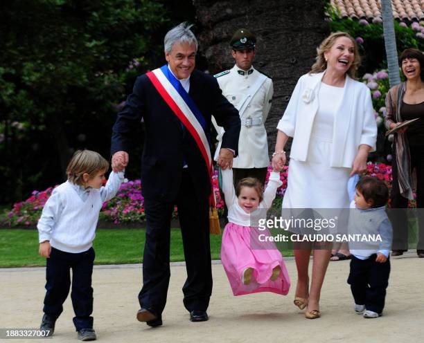 Chilean President Sebastian Piñera and his wife Cecilia Morel play with their grandchild at Cerro Castillo Palace in Vina Del Mar, on March 11, 2010....