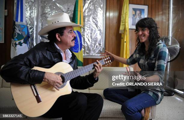 Honduran deposed President Manuel Zelaya plays the guitar next to his daughter Hortencia Xiomara, at the Brazilian embassy in Tegucigalpa, on...