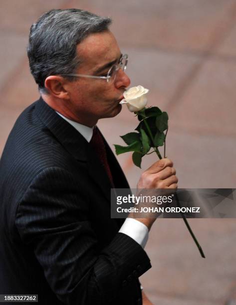 Colombian President Alvaro Uribe kisses the "Peace Rose" at the Culture Palace in Guatemala City October 13, 2009. AFP PHOTO Johan ORDONEZ