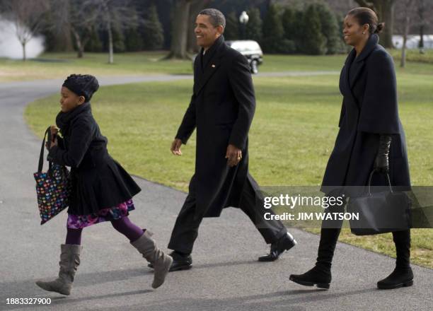 President Barack Obama arrives on the South Lawn of the White House in Washington, DC, with First Lady Michelle Obama and his daughter Sasha upon...