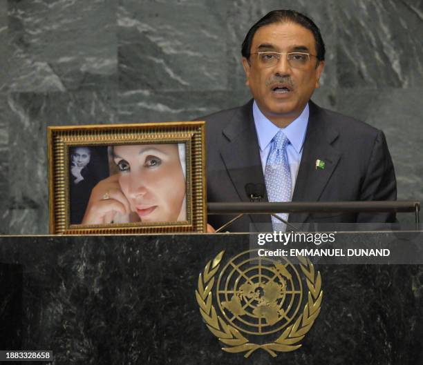 Pakistani President Asif Ali Zardari speaks next to a portrait of his late wife, slained politician Benazir Bhutto and her slained father Zulfikar...