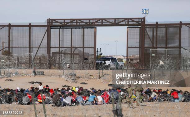 Migrants seeking asylum wait to be processed by the United States Border Patrol after having crossed the Rio Grande River from Ciudad Juarez,...