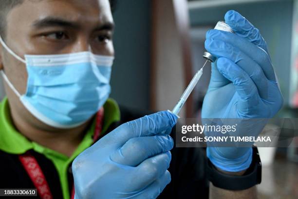 Health worker prepares the Inavac Covid-19 coronavirus booster vaccine for airport workers at Ngurah Rai Airport near Denpasar on the Indonesian...