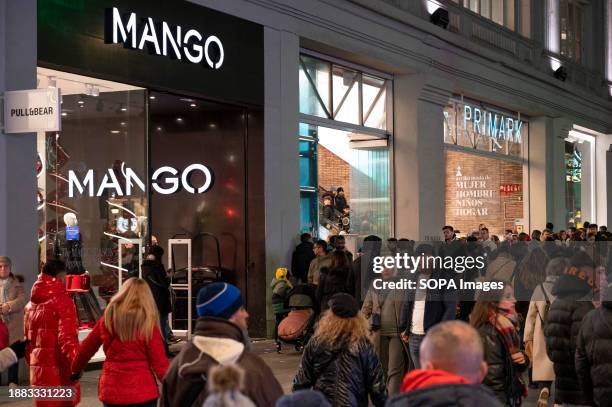 Shoppers and pedestrians walk past the Spanish multinational clothing design retail company Mango and Irish fashion retailer brand Primark stores in...