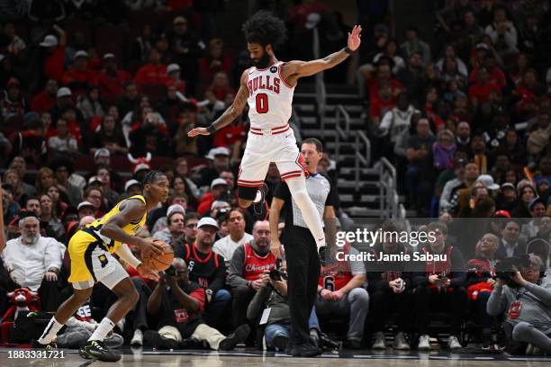 Coby White of the Chicago Bulls jumps over Bennedict Mathurin of the Indiana Pacers in the second half on December 28, 2023 at the United Center in...