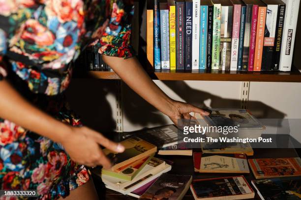Namwali Serpell moves a copy of "Huckleberry Finn" by Mark Twain in her office at Harvard University in Cambridge, MA on Sept. 6, 2023. Serpell...