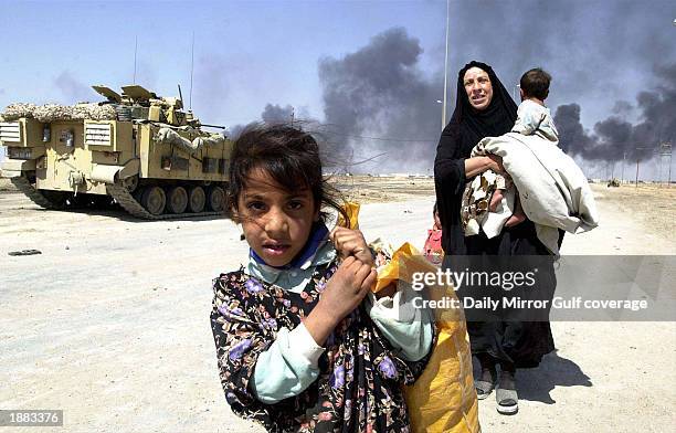 Residents flee the burning town of Basra March 28, 2003 in Iraq. U.S. Bombing continues as coalition forces carry out an operation to oust Iraqi...