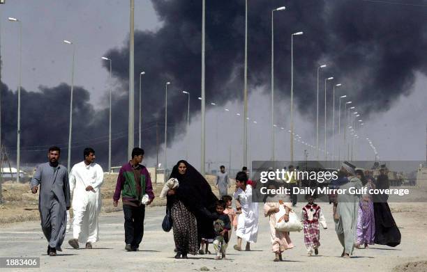 Residents flee the burning town of Basra March 28, 2003 in Iraq. U.S. Bombing continues as coalition forces carry out an operation to oust Iraqi...