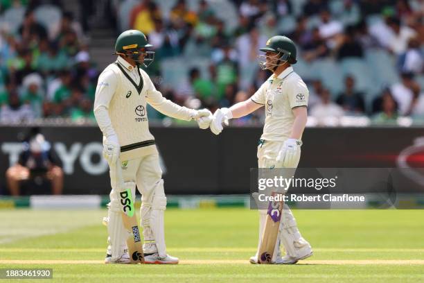 Usman Khawaja and David Warner of Australia fist bump during day one of the Second Test Match between Australia and Pakistan at Melbourne Cricket...