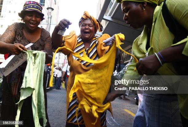 Supporters of former defence minister Terror Lekota tear t-shirts bearing faces of ANC president Jacob Zuma outside the convention centre on November...