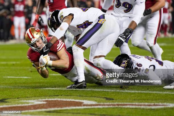 Christian McCaffrey of the San Francisco 49ers dives past Marlon Humphrey of the Baltimore Ravens while scoring a rushing touchdown during the second...