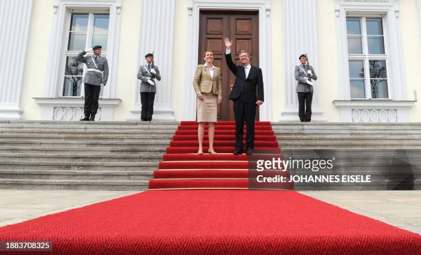 Germany's new President Christian Wulff and his wife Bettina Wulff pose in front of the Bellevue Palace after he was greeted with military honours...
