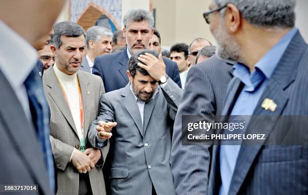 Iranian President Mahmoud Ahmadinejad gestures as he makes his way through a crowd outside the Iranian pavilion during his visit at the site of the...