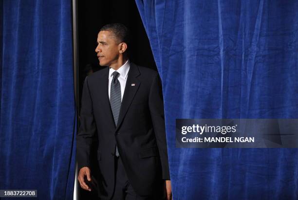 President Barack Obama walks through a set of curtains to speak at a fundraiser for Senator Barbara Boxer and the Democratic Senatorial Campaign...