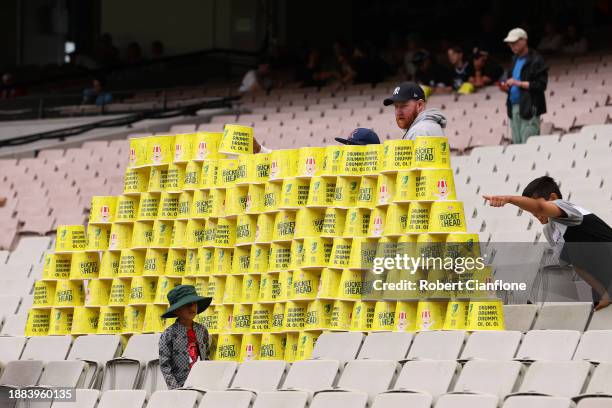 Young fans create a bucket tower during a rain delay on day one of the Second Test Match between Australia and Pakistan at Melbourne Cricket Ground...