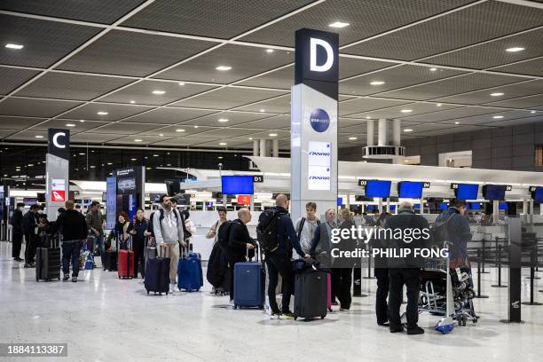 Passengers walk with their luggage at the departure hall of Narita International Airport in Narita, Chiba Prefecture, outside Tokyo ahead of the New...