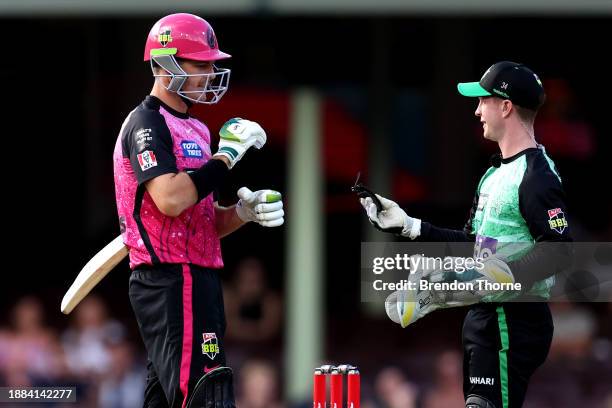 Sam Harper of the Stars hands Daniel Hughes of the Sixers a piece of his helmet after being hit on the helmet during the BBL match between Sydney...
