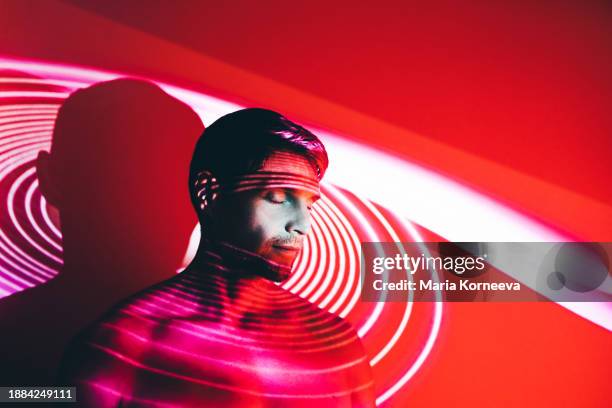 man covered by colorful abstract patterns projected onto his face. - lightning bolt pose - fotografias e filmes do acervo