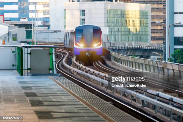 elevated view of metro train arrive to station on evening  in sukhumvit,bangkok thailand - sydney metro stock pictures, royalty-free photos & images